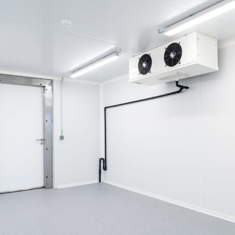 an empty industrial room refrigerator with four fans
