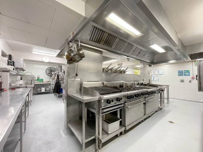 Commercial kitchen with stainless steel benches and epoxy flooring