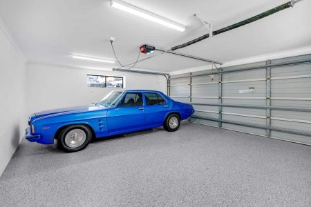 Blue classic sedan in a garage with Hastings epoxy flake flooring