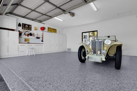 Salt and Pepper epoxy flake garage floor with white cabinets and a classic car