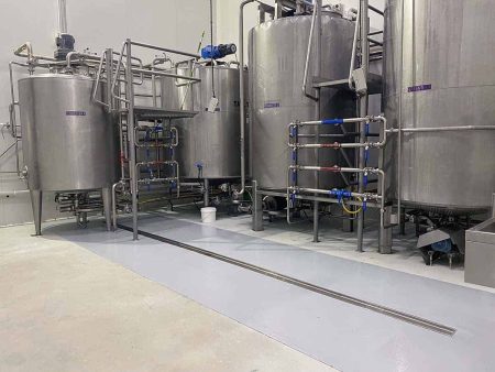 Stainless steel tanks on epoxy flooring in a production plant