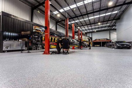 Mechanical workshop with red car hoists on epoxy flake flooring