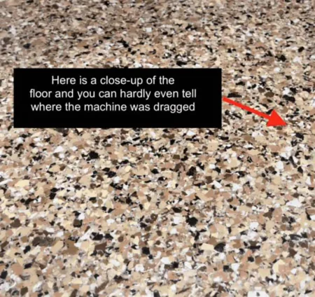 Close up of scratch resistant epoxy flake flooring after a machine was dragged