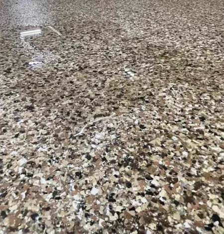 Water sitting on top of a waterproof epoxy flake floor